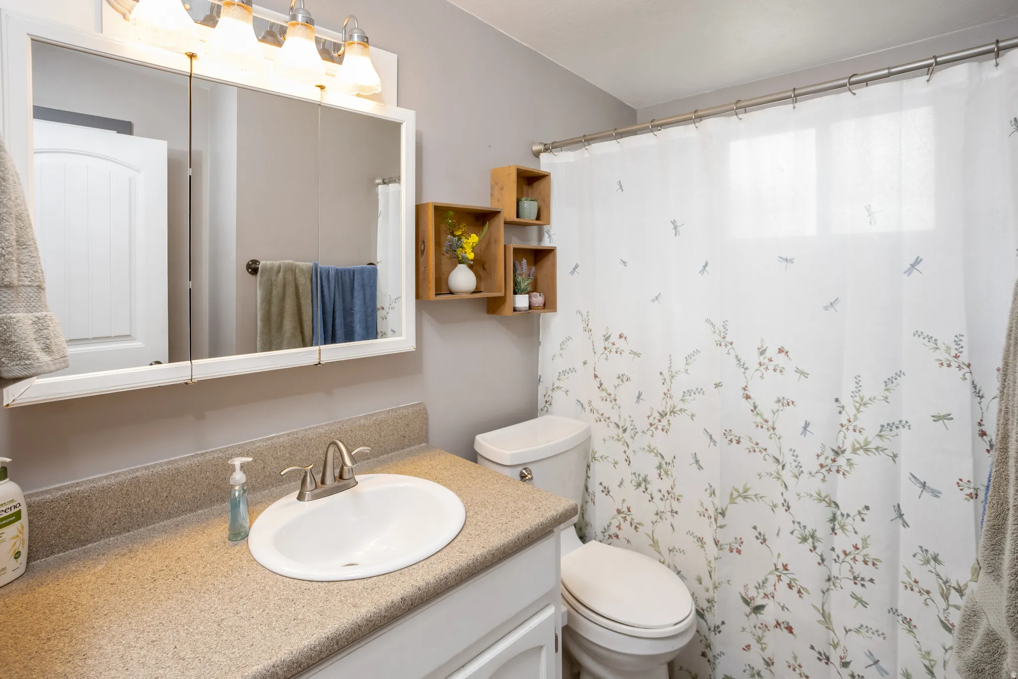 Vanity with integrated sink, brushed nickel faucet, and speckled countertop