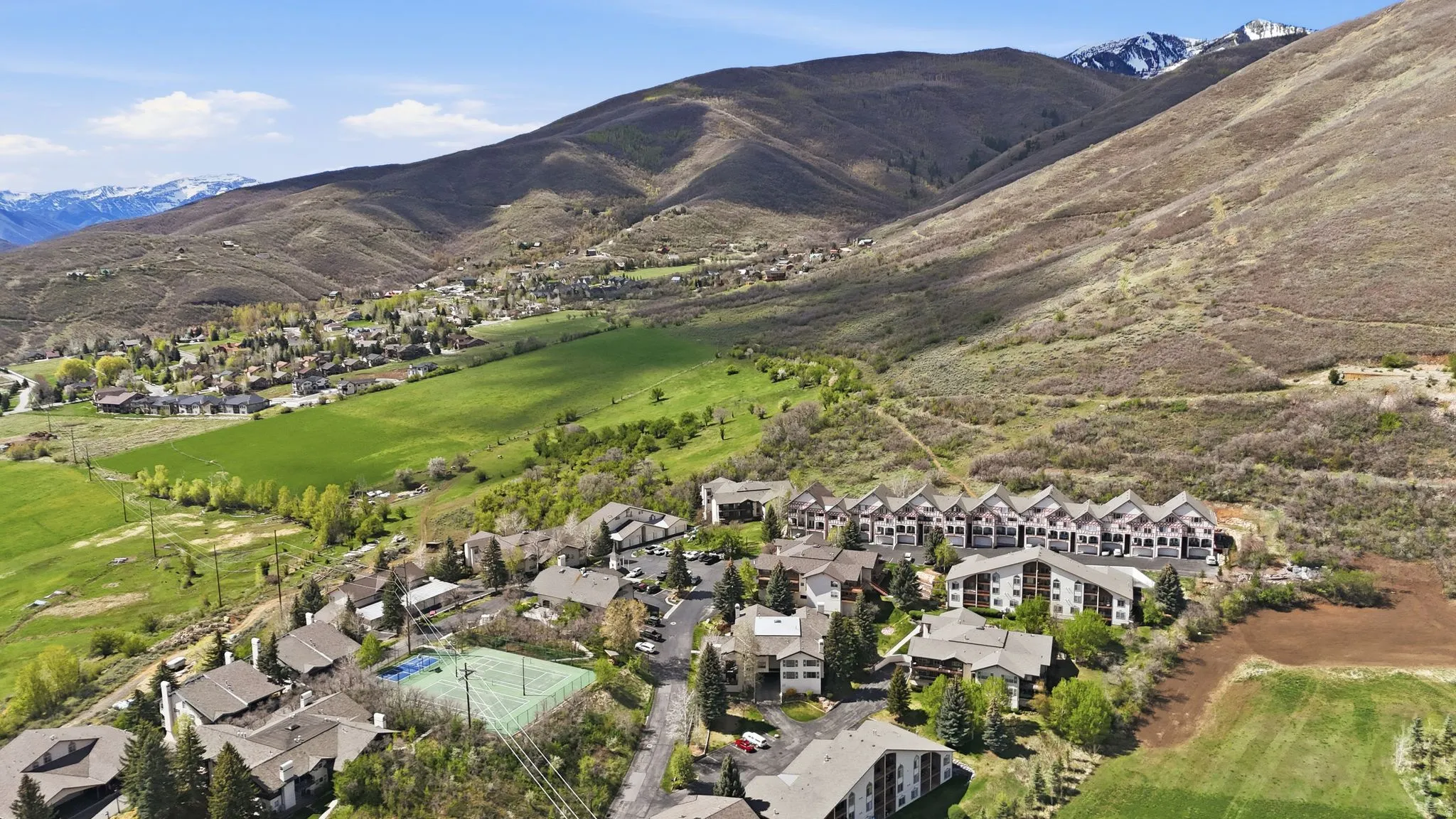 Aerial perspective showcasing a residential community nestled against a mountainous backdrop