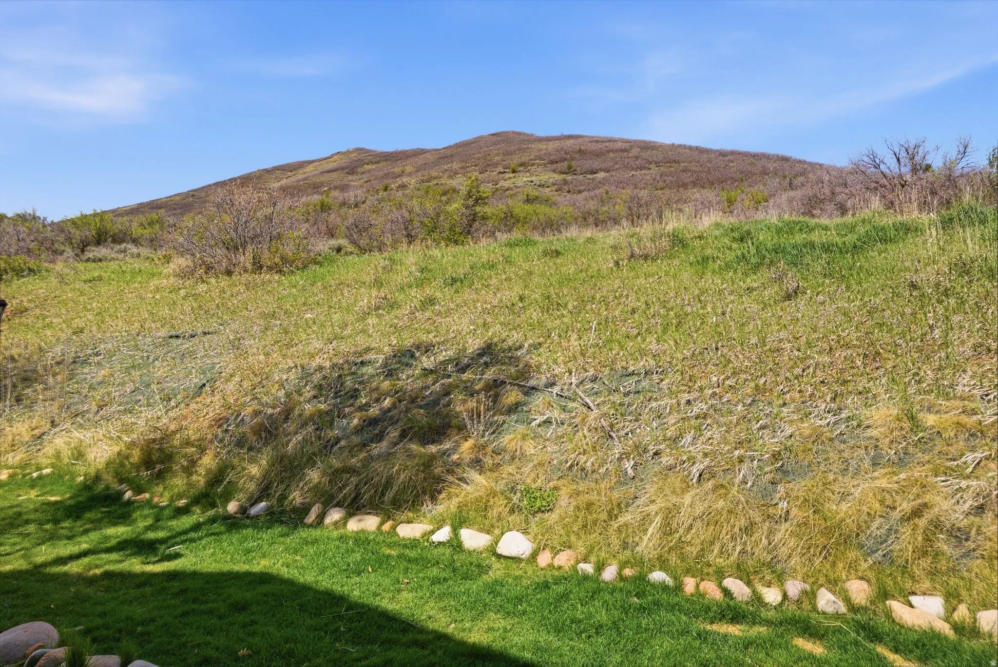 Expansive natural landscape with a partial manicured lawn in the foreground