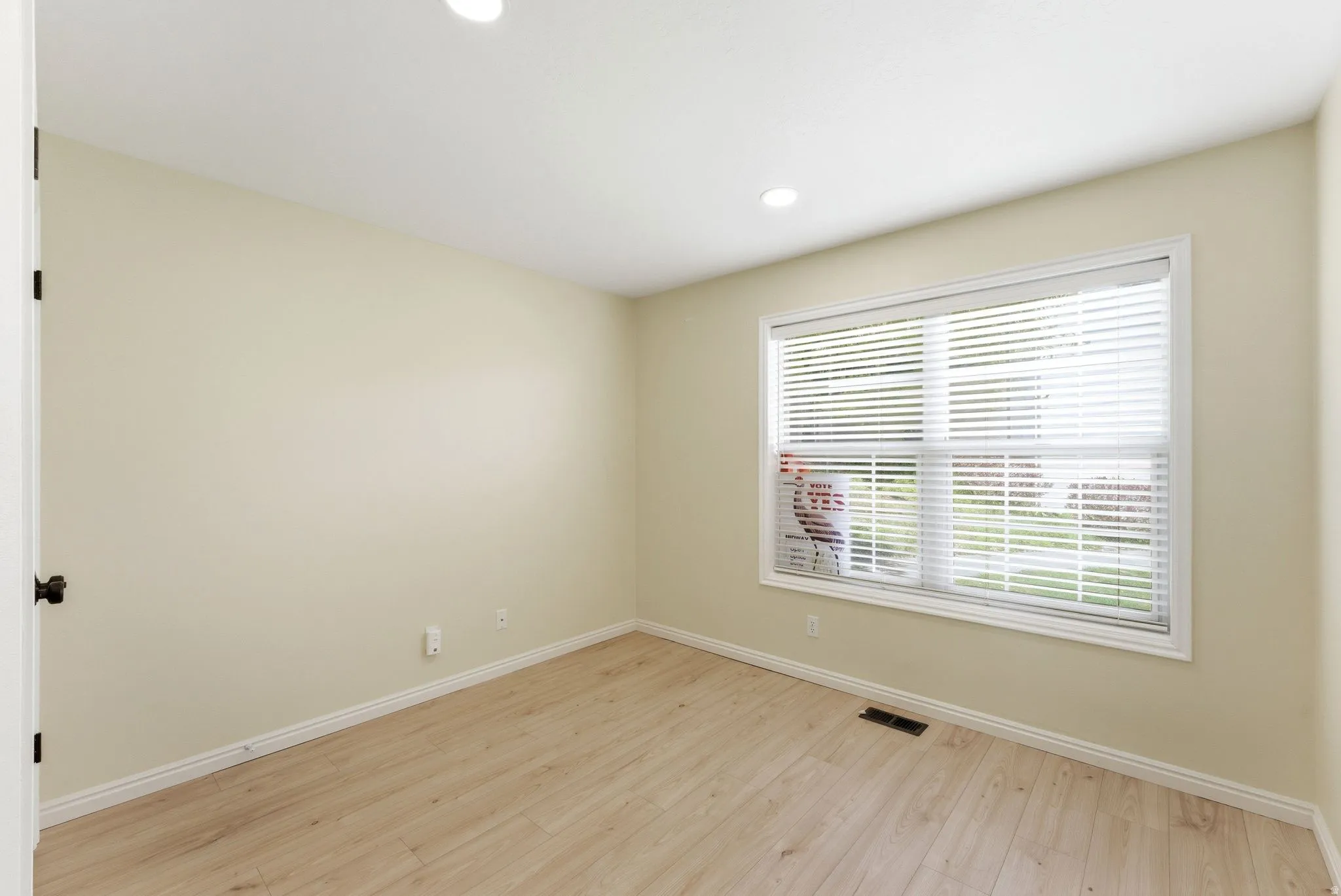 Room featuring light-toned walls and wood-finish flooring