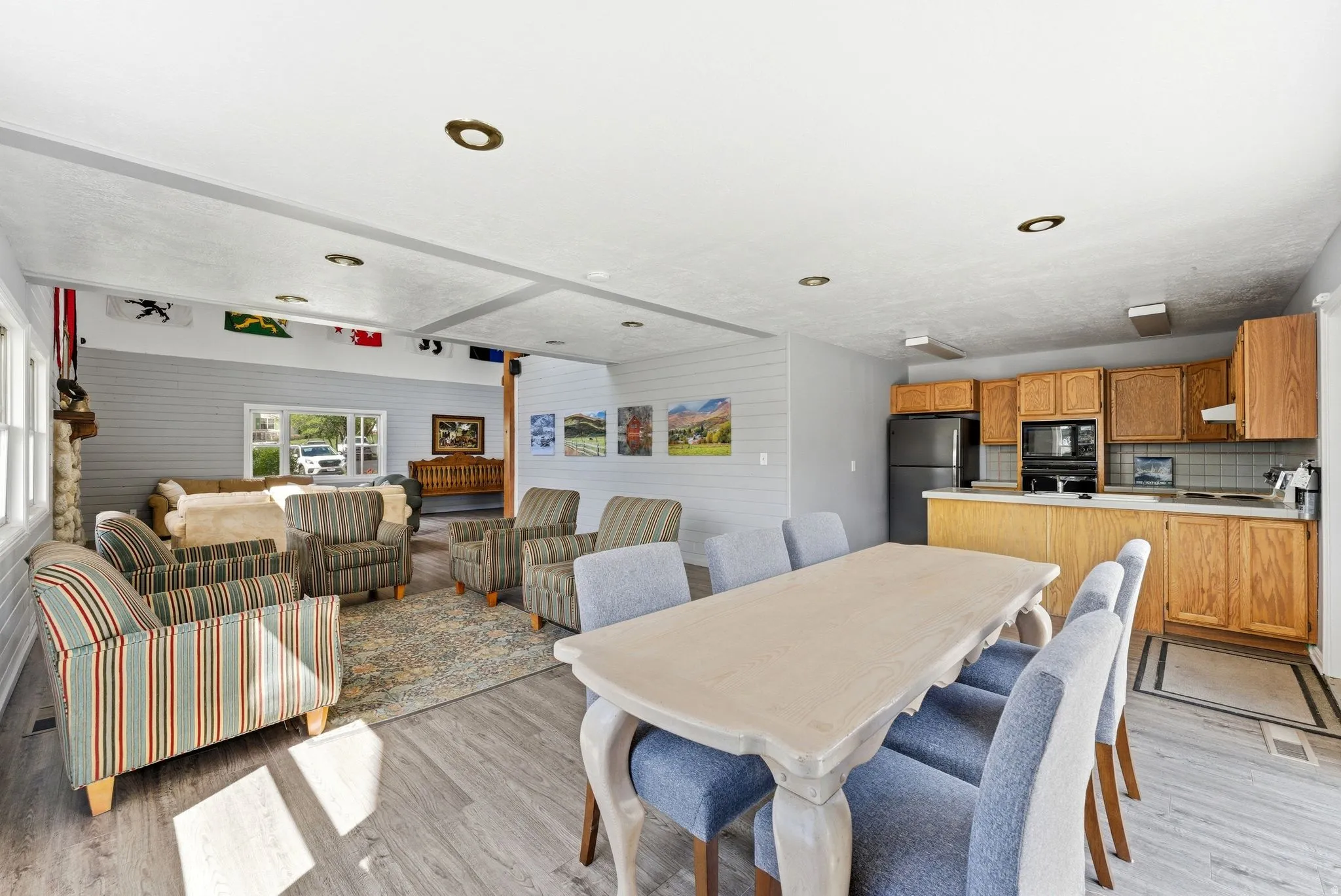 Open-concept interior featuring wood-finish flooring, recessed lighting, and a stone-clad fireplace