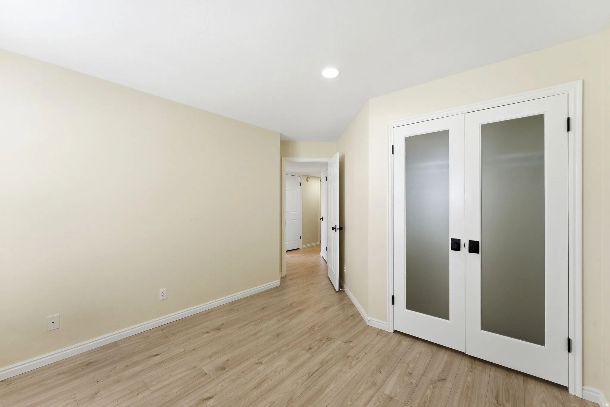Light wood-finish flooring complemented by white baseboards