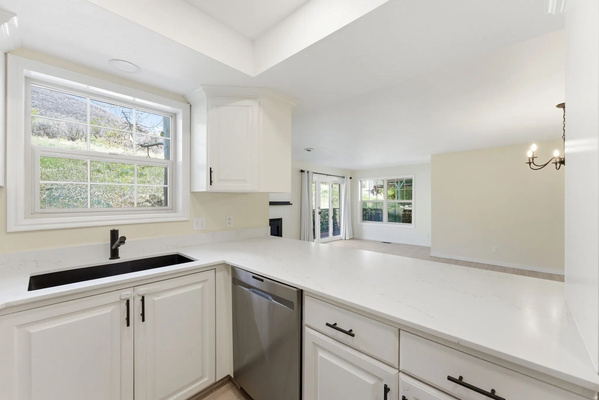 Kitchen featuring white cabinetry, a black rectangular sink with a matte black faucet, and a stainless steel dishwasher
