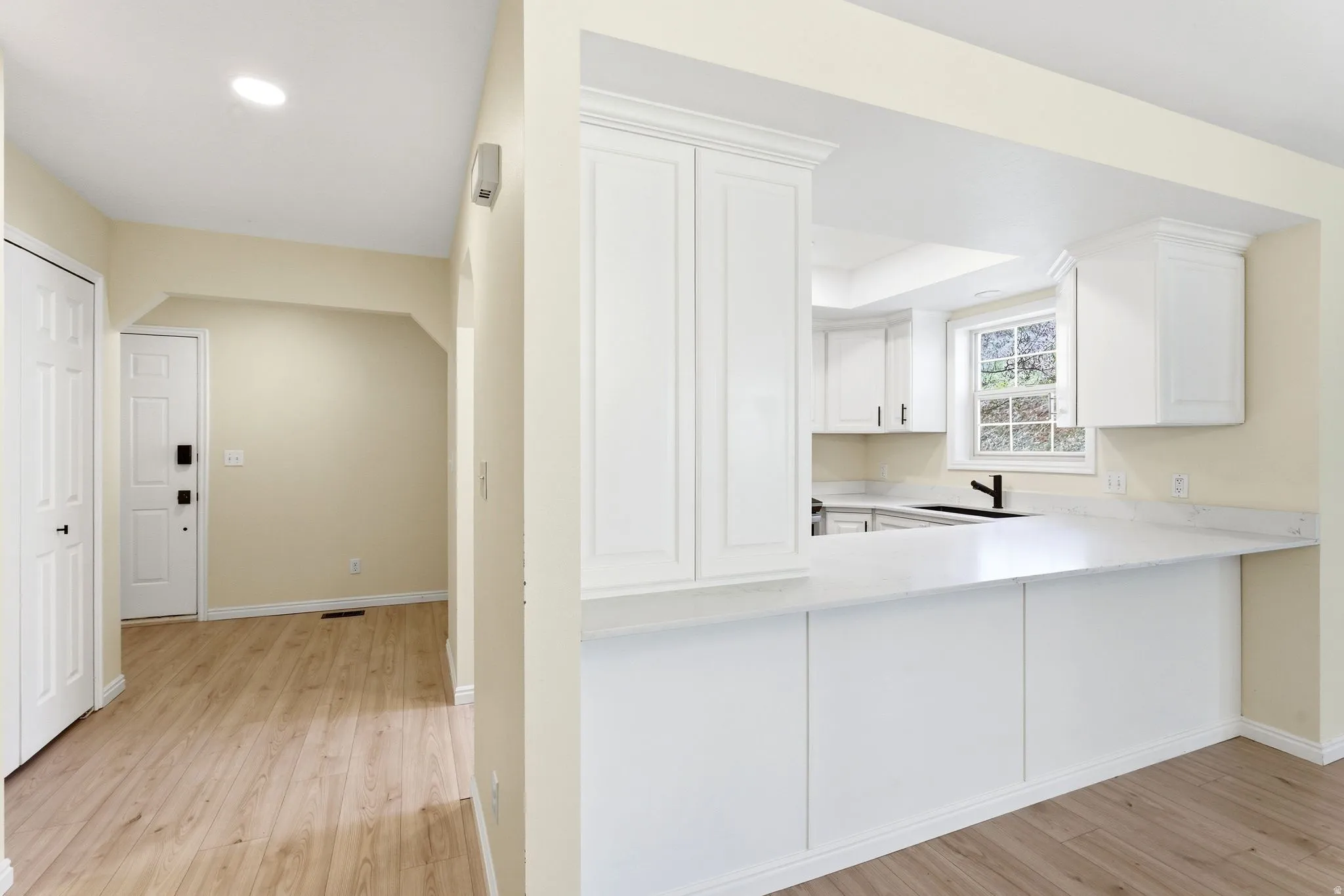 Kitchen pass-through with white cabinetry and quartz countertops