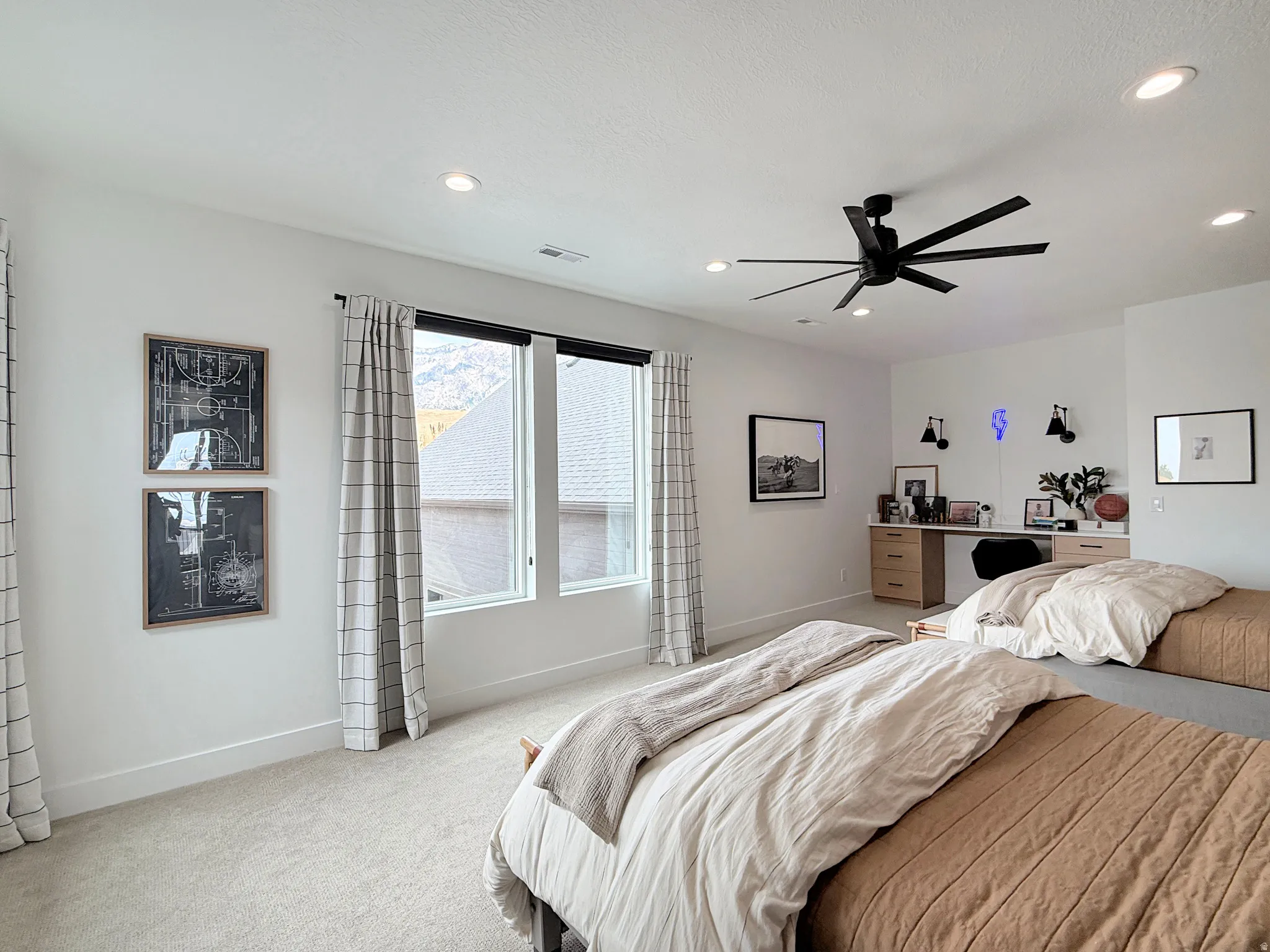 Carpeted bedroom featuring large windows, a built-in desk with wood-finish cabinetry, recessed lighting, and a modern ceiling fan