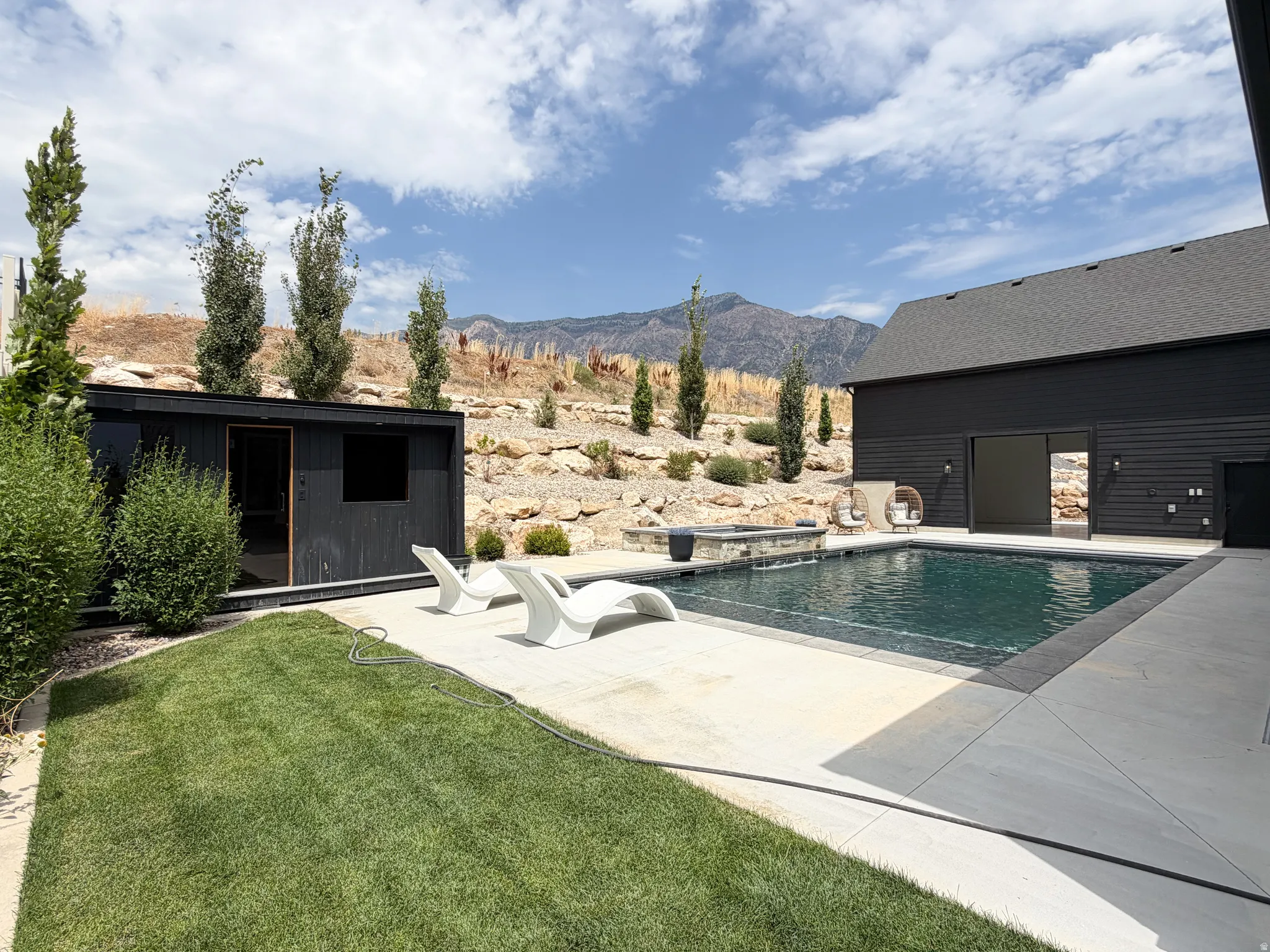 Outdoor swimming pool with integrated spa and concrete surround