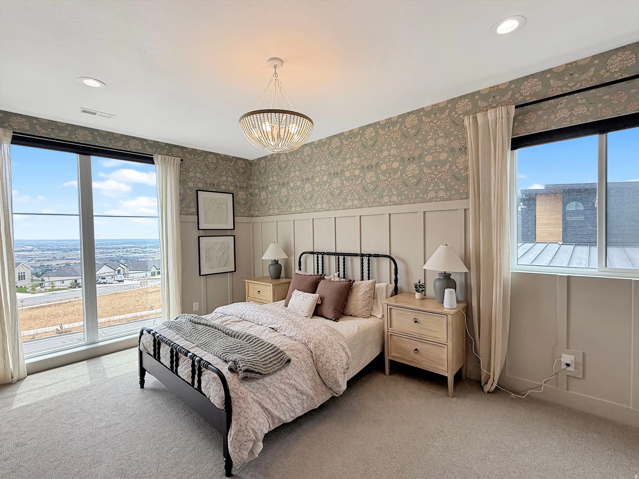 Expansive picture window, patterned wallpaper, recessed lighting, chandelier, and wall paneling