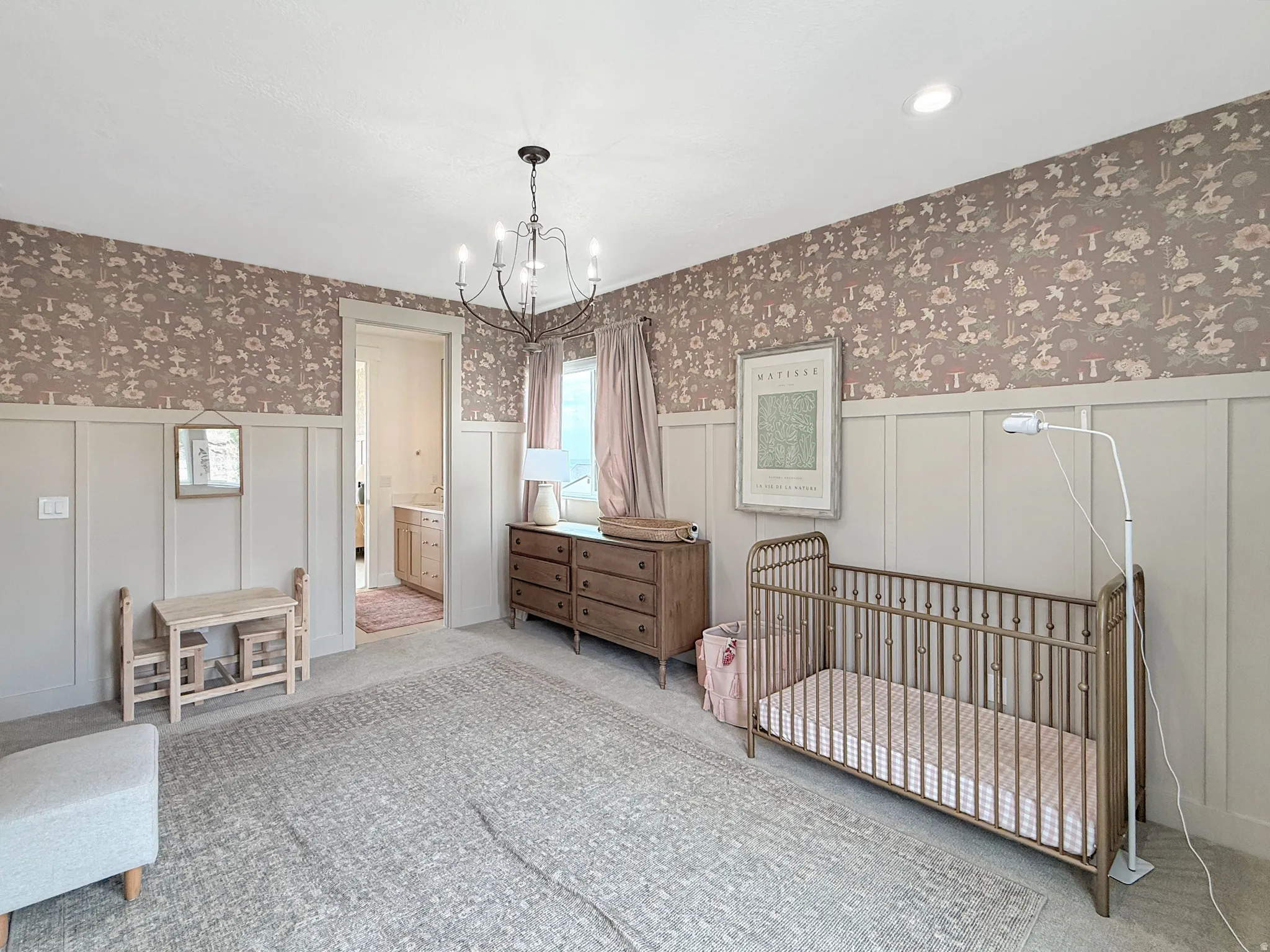 Board and batten wainscoting, decorative wallpaper, recessed lighting, and a chandelier illuminate the interior