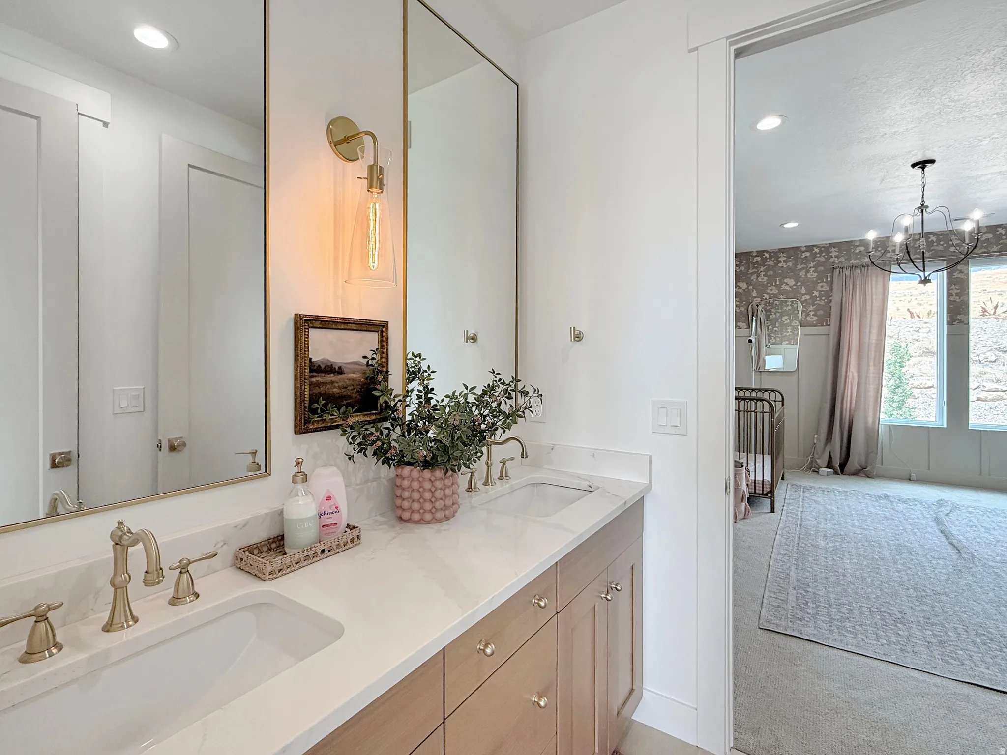 Dual vanity with gold-finish mirrors and wall-mounted sconces