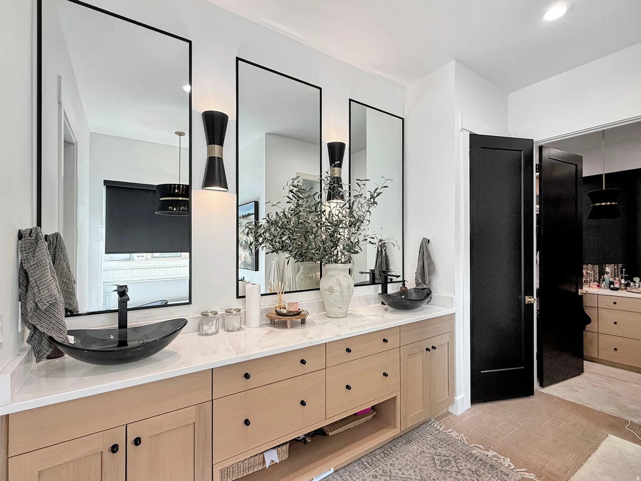 Dual vessel sinks with wall-mounted faucets and pendant lighting