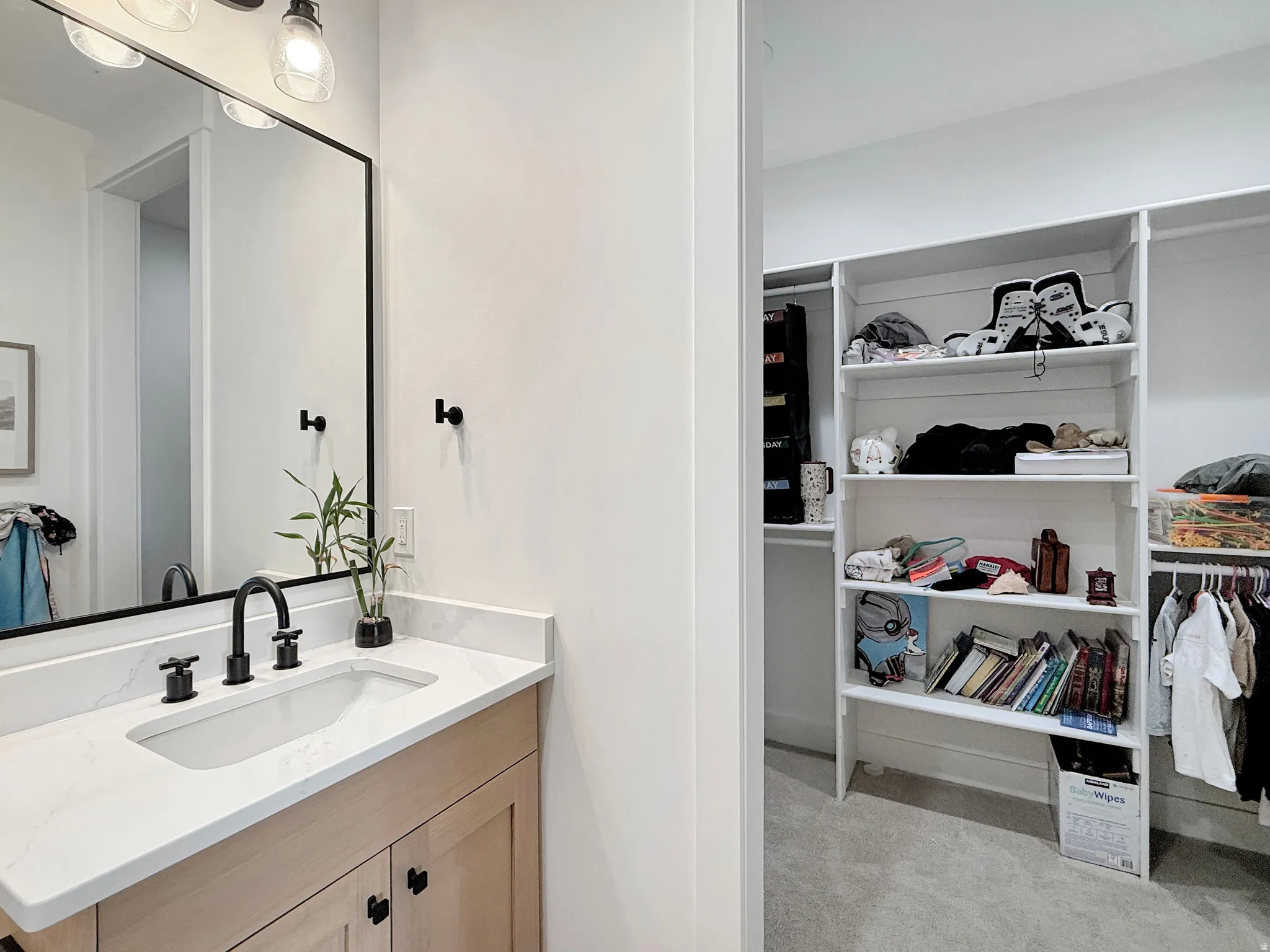 Vanity with matte black fixtures, rectangular undermount sink, and light wood-finish cabinetry