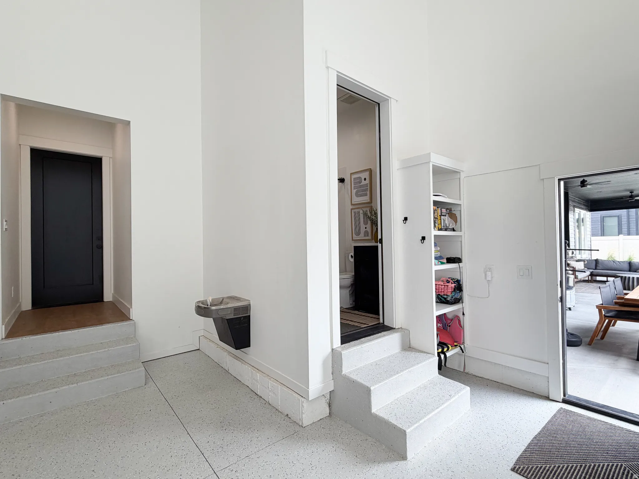 White terrazzo flooring, built-in shelving, and a built-in water dispenser