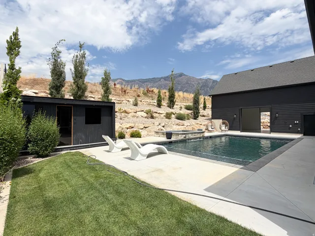 Outdoor swimming pool with integrated spa and concrete surround