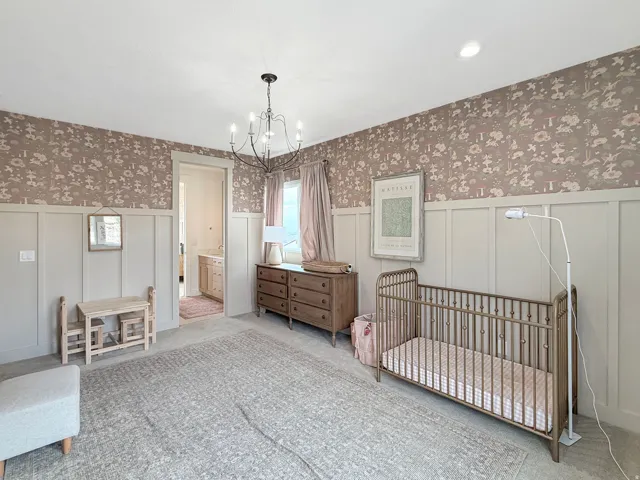 Board and batten wainscoting, decorative wallpaper, recessed lighting, and a chandelier illuminate the interior