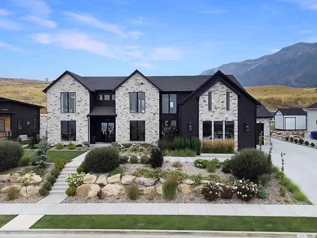 Modern two-story residence with a black and light-toned stone exterior