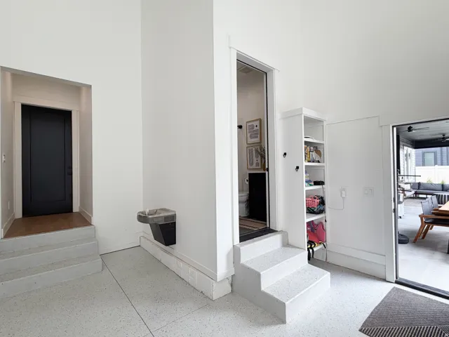White terrazzo flooring, built-in shelving, and a built-in water dispenser