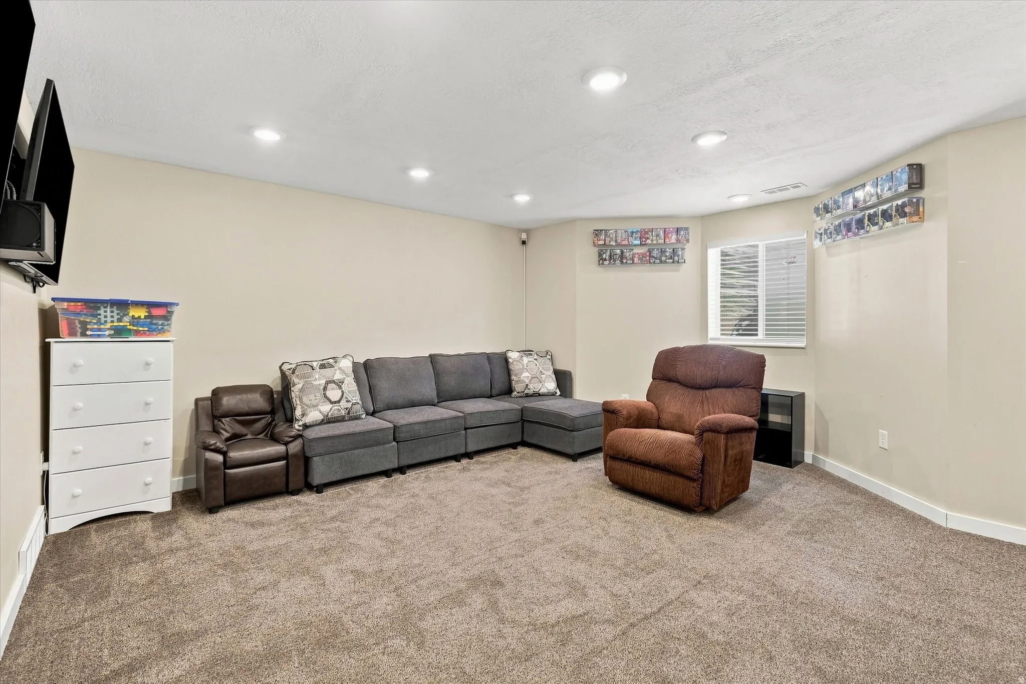 Recessed ceiling lighting, window with blinds, and neutral-toned carpeting