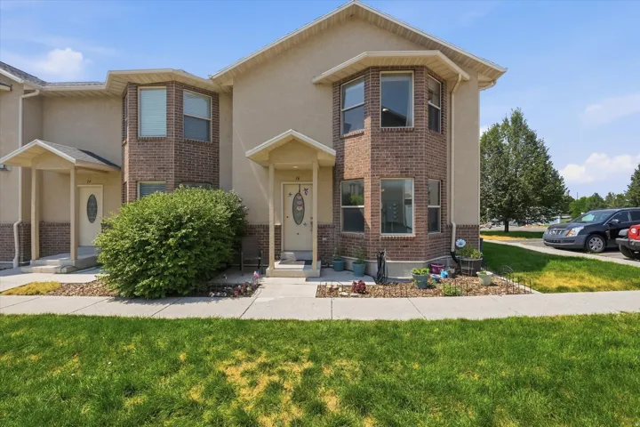 Stucco and brick exterior with bay windows and covered entryways
