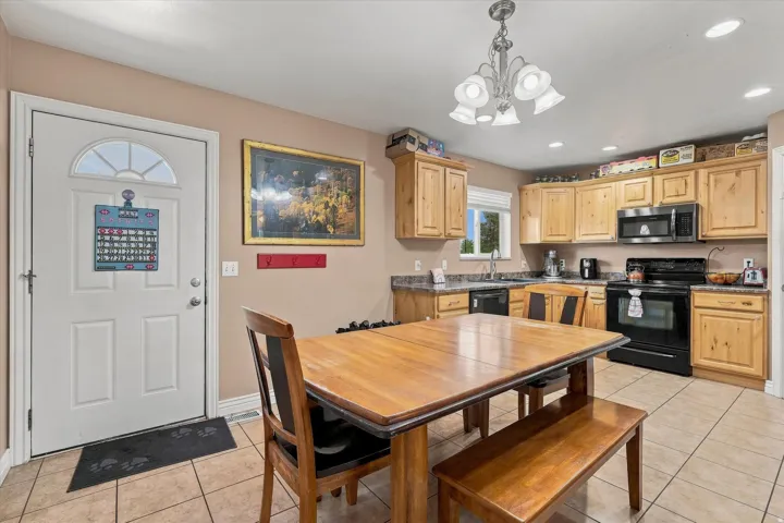 Kitchen with wood-finish cabinetry, dark countertops, and tile flooring