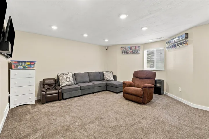 Recessed ceiling lighting, window with blinds, and neutral-toned carpeting