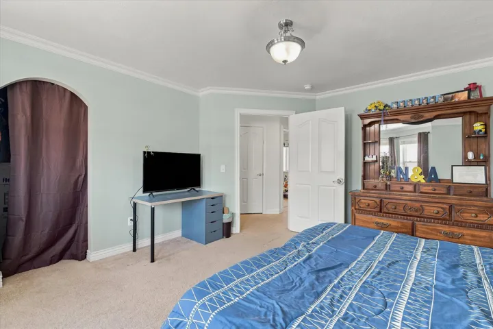 Ceiling-mounted light fixture, crown molding, and an arched entryway