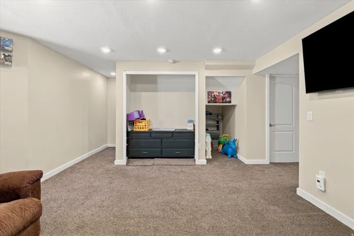 Recessed lighting illuminates the carpeted flooring