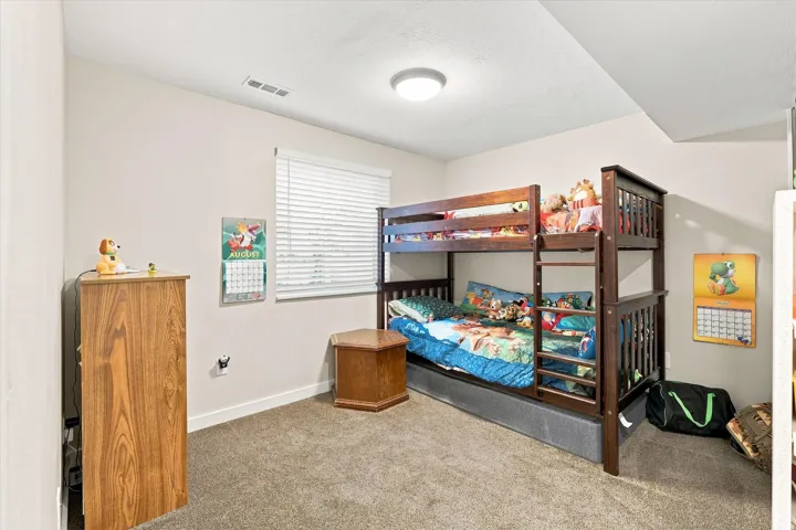Recessed window with horizontal blinds, overhead flush mount lighting, and neutral carpet flooring