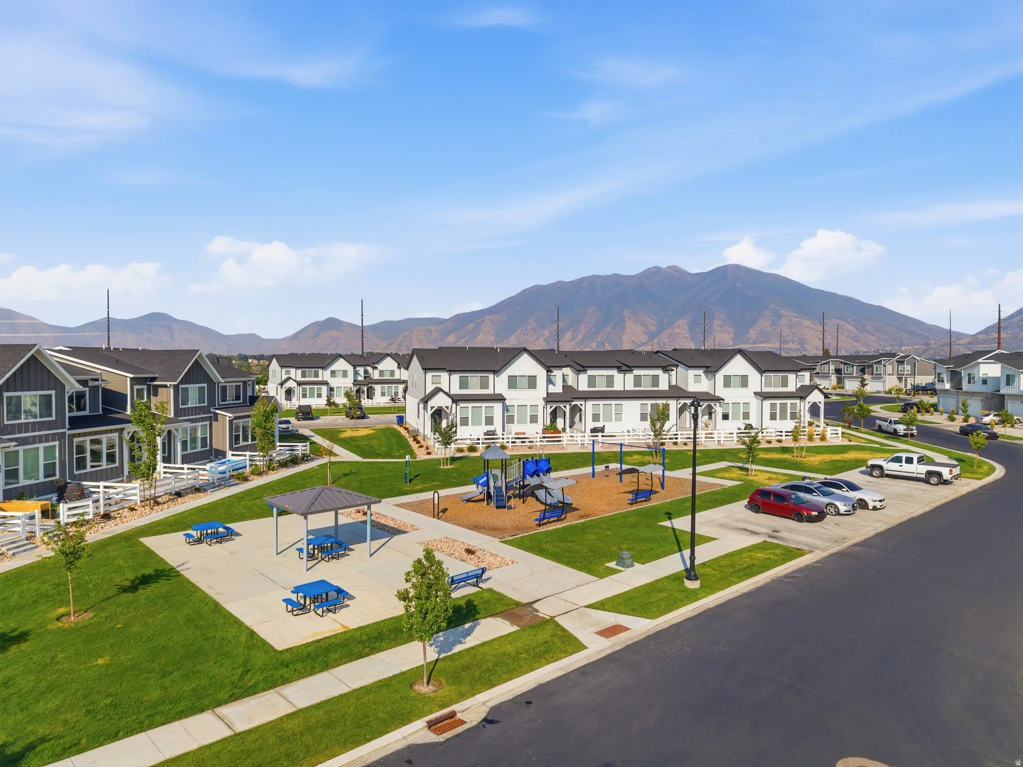 Community green space featuring a playground, shaded picnic area, and paved pathways