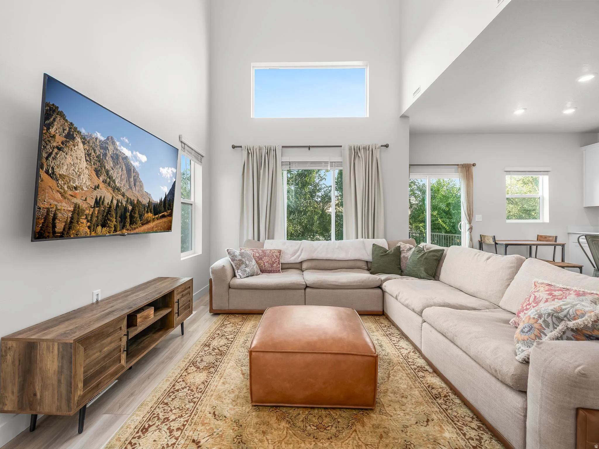 Vaulted ceilings with clerestory windows, wood-finish flooring, and sliding glass doors