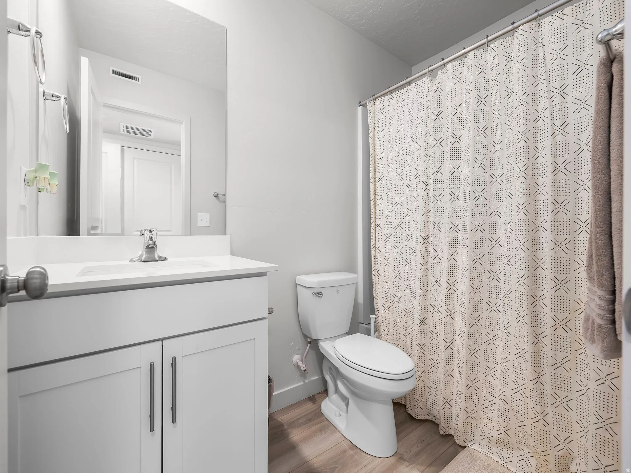 White vanity with a single basin sink and stainless steel faucet
