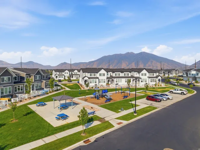 Community green space featuring a playground, shaded picnic area, and paved pathways
