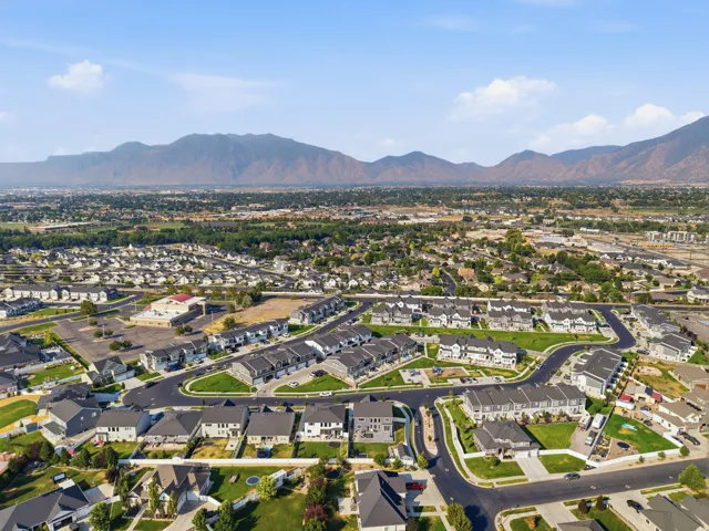 Aerial view showcasing a planned residential community with curved street layouts, manicured landscaping, and new construction homes