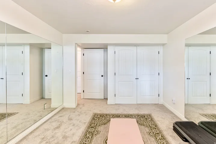 Wall-to-wall carpeting, full-height wall mirrors, double doors, and white trim