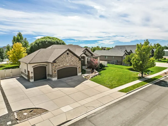 Stone and stucco exterior with a prominent two-car garage featuring arched doors