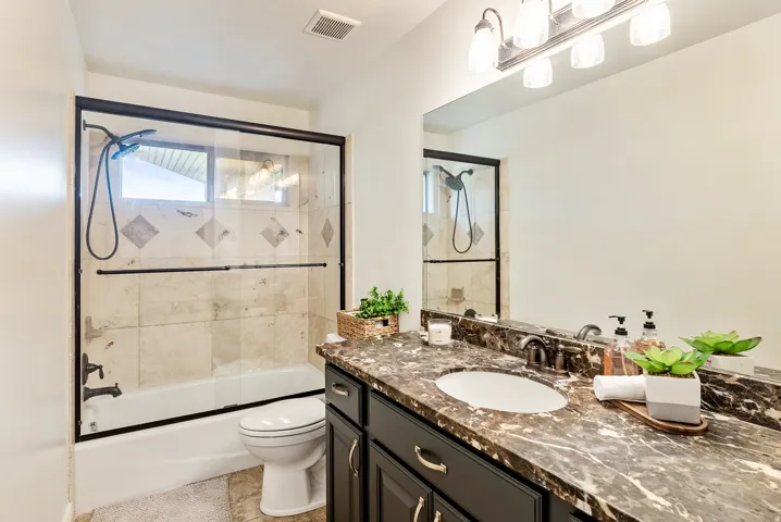 White tub with a black-framed glass enclosure