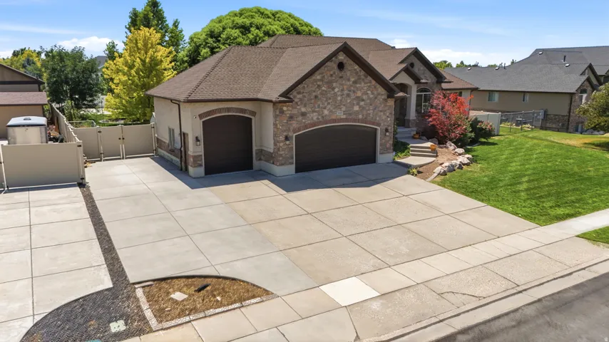 Stone and stucco exterior with a multi-car driveway