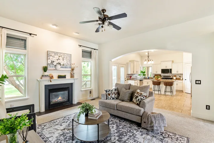Living area featuring a fireplace with a dark surround and white mantel, two windows, and recessed lighting
