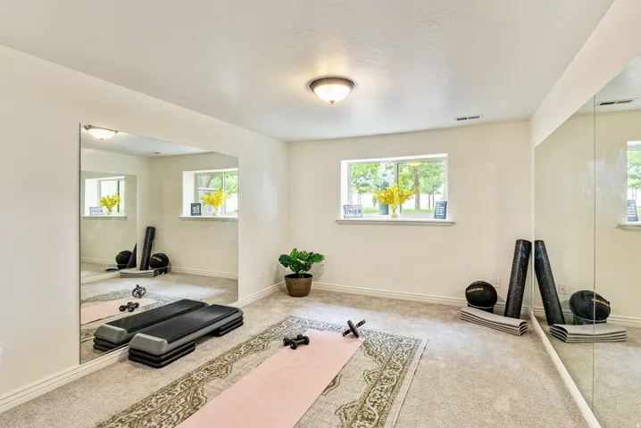 Recessed lighting illuminating a spacious room with wall-mounted mirrors and two windows