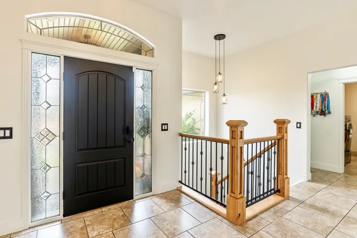 Arched transom window above a paneled entry door with decorative glass sidelights
