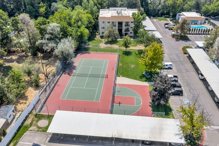 Outdoor tennis court, basketball court, swimming pool, covered parking, and multi-story building