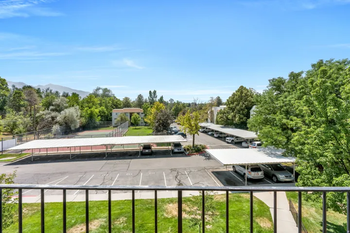 Mountain backdrop, mature trees, tennis court, covered parking, and green space
