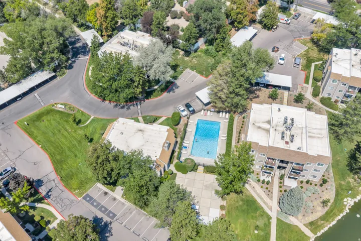 Community amenities include a swimming pool, covered parking structures, and mature landscaping