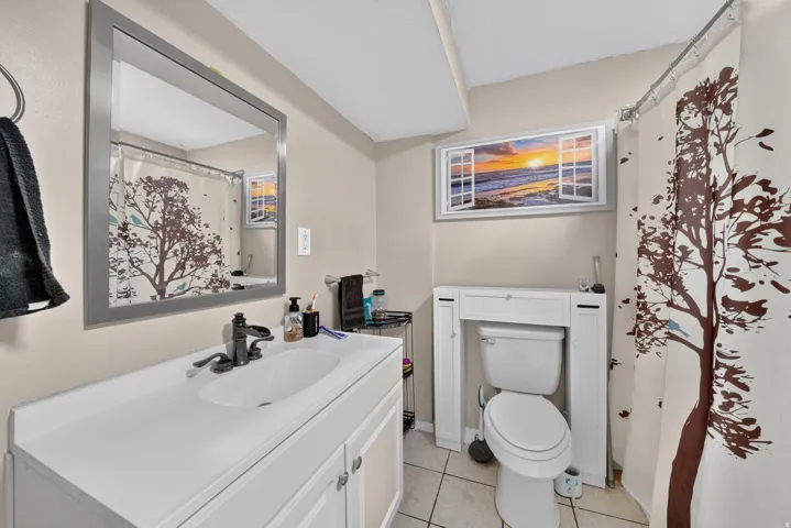White vanity with integrated sink, black-finish faucet, and coordinating framed mirror