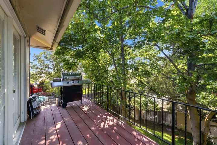 Outdoor deck with wood-finish flooring and black wrought iron railing