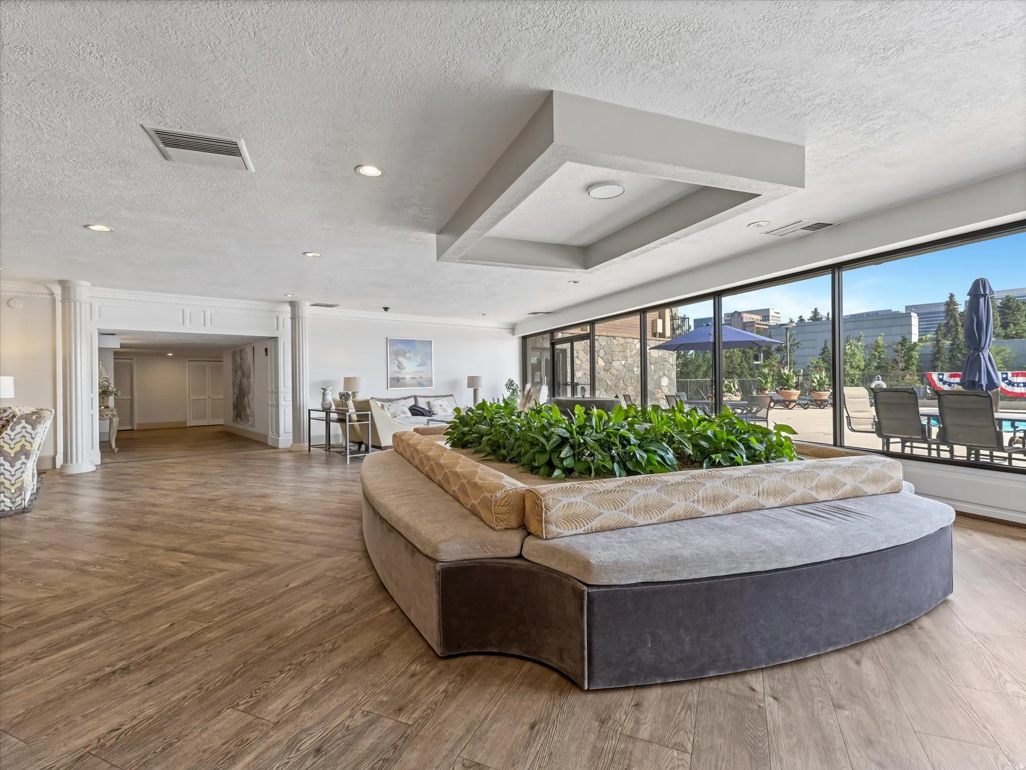 Wood-finish flooring, recessed lighting, and a built-in planter with seating define this interior space