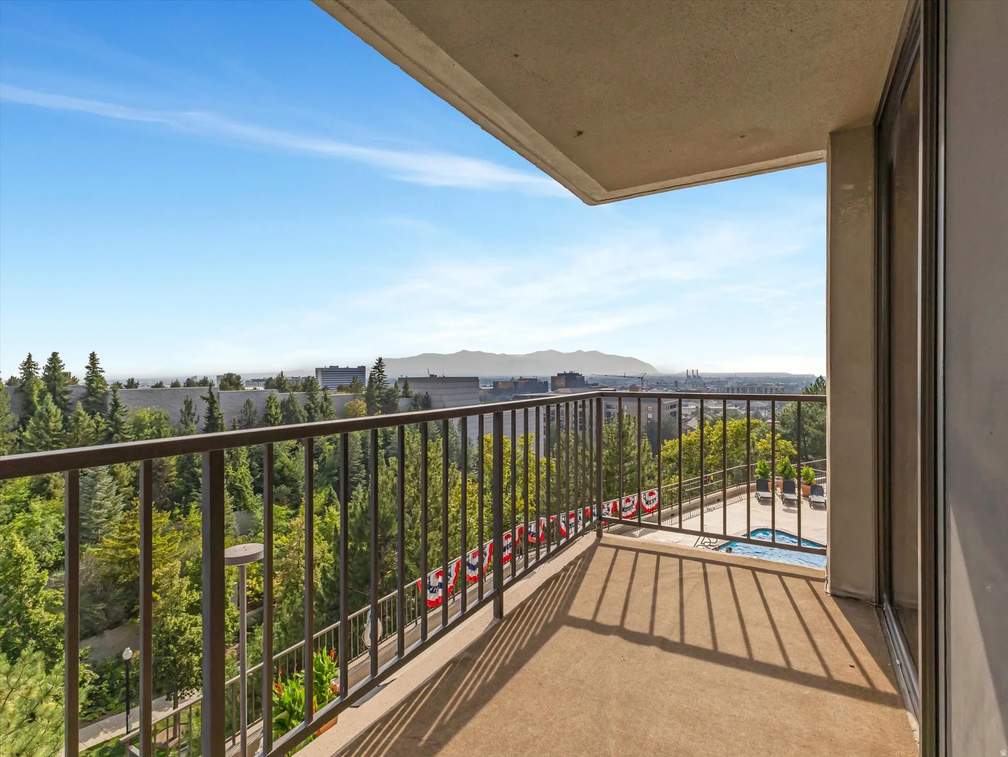Balcony with concrete flooring, metal railing, and glass sliding door