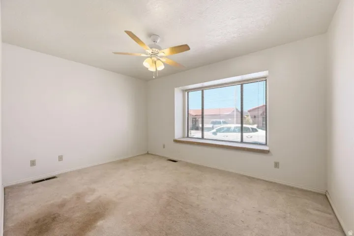 Recessed window with a sill, neutral carpeting, and a ceiling fan with integrated lighting