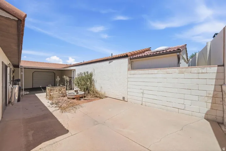 Attached garage featuring a sectional door, stucco exterior, and concrete flooring
