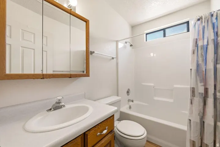 Built-in vanity with wood-finish cabinetry, a single basin sink, and a mirrored medicine cabinet