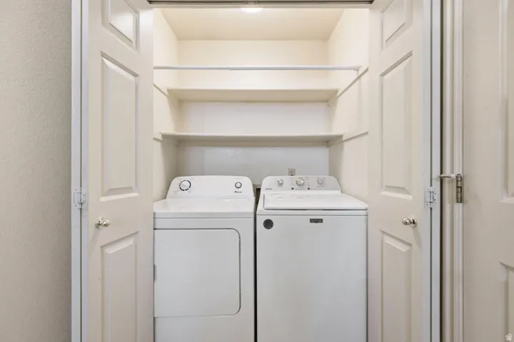 Integrated laundry closet featuring upper shelving, a clothes rod, and bi-fold doors